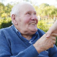 Elderly man holding a hand