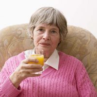 woman-sitting-drinking-orange-juice