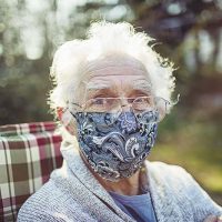 senior-woman-sitting-outside-with-mask