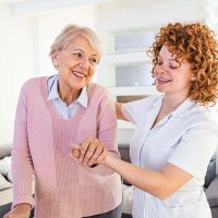 happy-senior-woman-getting-assistance-from-caregiver