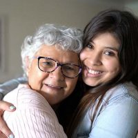 senior hugging family caregiver