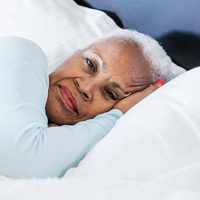 senior-woman-laying-in-bed