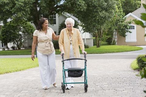 A woman providing Brewerton home care takes a walk around the neighborhood with her senior client.