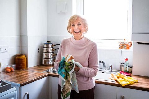 A woman dries dishes to practice independence in seniors with dementia.