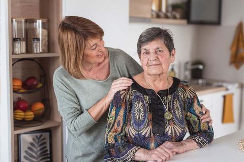 A woman experiencing time-shifting in Alzheimer’s stares ahead as her daughter places a hand on her shoulder.