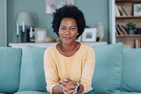 A woman smiles confidently as she knows she’s growing stronger through the ups and downs of caregiving.