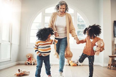 A woman knows that improving your balance helps you live longer, so she practices exercises with her two grandchildren.