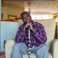 A man sits in a chair, at risk for sitting disease in older adults if he doesn’t get more physical activity.