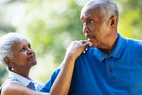 A man struggling with impulsive behaviors in dementia is comforted by his wife.
