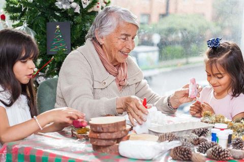 A woman with dementia and her granddaughters work together on making story ornaments.