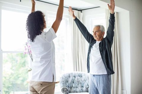 A man who asked himself, “What are mind-body exercises for seniors?” learns how to practice them with his caregiver.
