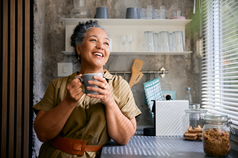 A woman takes a break from senior care to enjoy a cup of coffee.