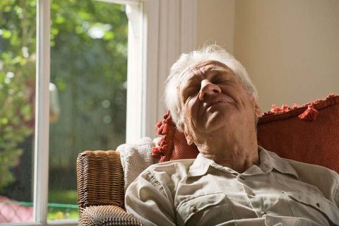 An older man struggling with excessive sleeping with dementia takes a nap.
